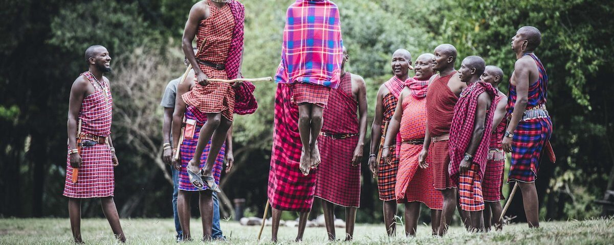 How do Maasai guides at Angama Mara enrich the walking safari experience?