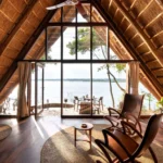 How Does the Design of Clouds Lodge Incorporate Local Volcanic Stone and Ugandan Artwork?
