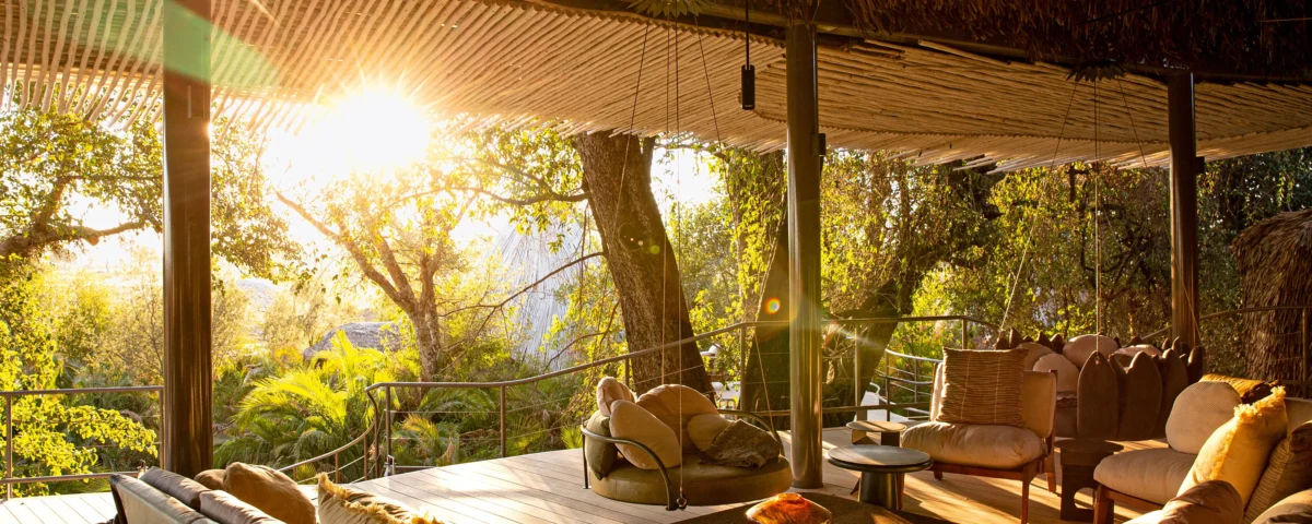 What unique architectural style sets The Highlands apart from traditional canvas safari camps?